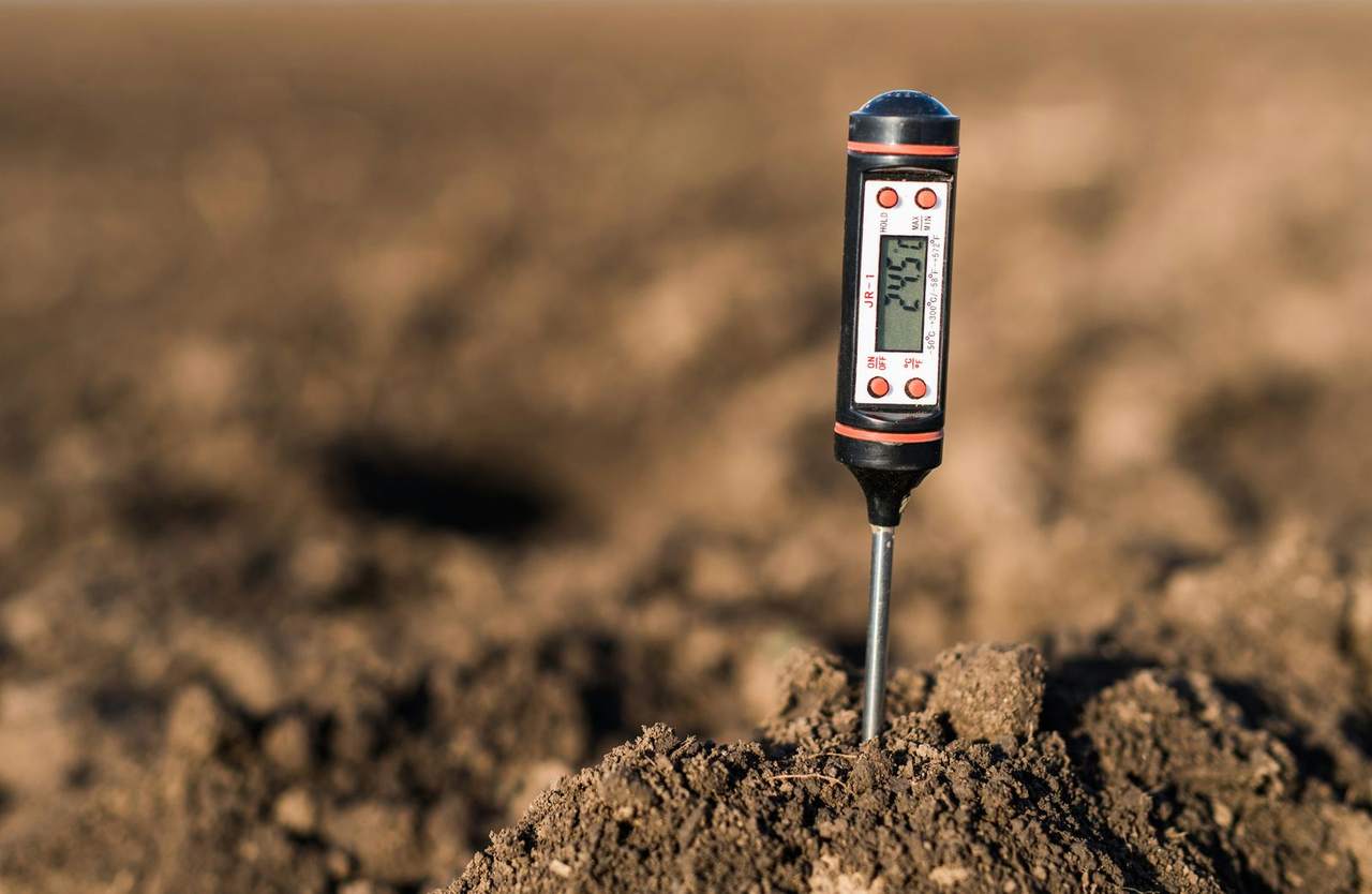 A digital soil probe pushed into bare cultivated soil